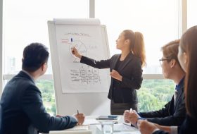 A woman is giving a presentation to an audience.